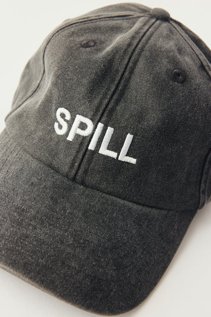 A dark gray washed cotton baseball cap with the word 'SPILL' embroidered in white across the front, shown on a plain light background.